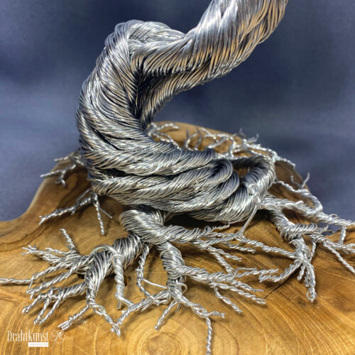 Baum der Weisheit: ein aus silberfarbenem Aluminiumdraht hergestellter Drahtbaum, der auf einer Teakholz-Baumscheibe thront